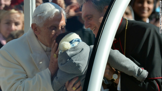 Pope Benedict XVI greets a baby on St Peter's square at the Vatican.