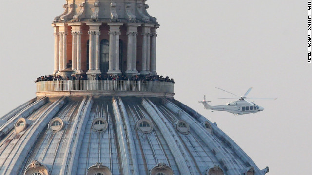 People crowd the gallery on top of St. Peter's Basilica as a helicopter carrying Pope Benedict XVI passes by on its way out of Vatican City.