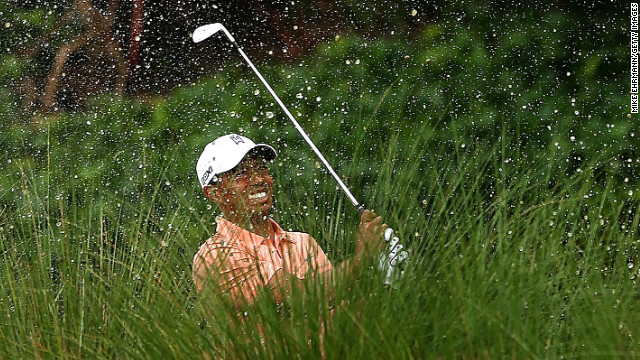 Tiger Woods has to play out of a water hazard on the sixth at PGA National on his way to a level-par 70 in the first round.