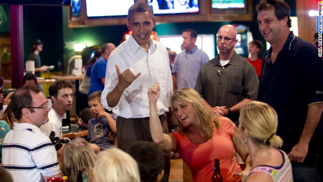 President Barack Obama, a native of Hawai, makes the Hawaiian symbol known as the 