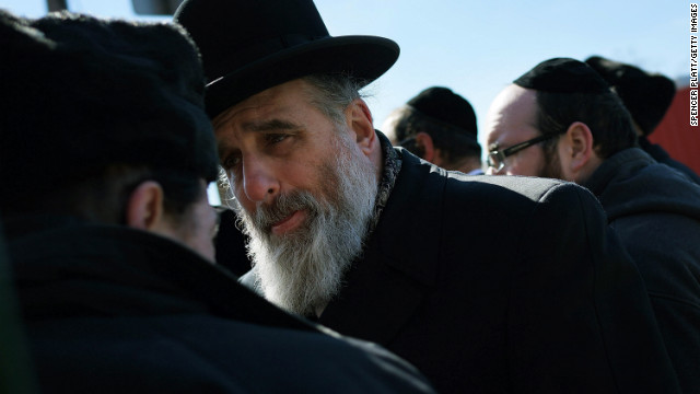 Two members of the Brooklyn Orthodox Jewish community talk before the news conference on Monday. 