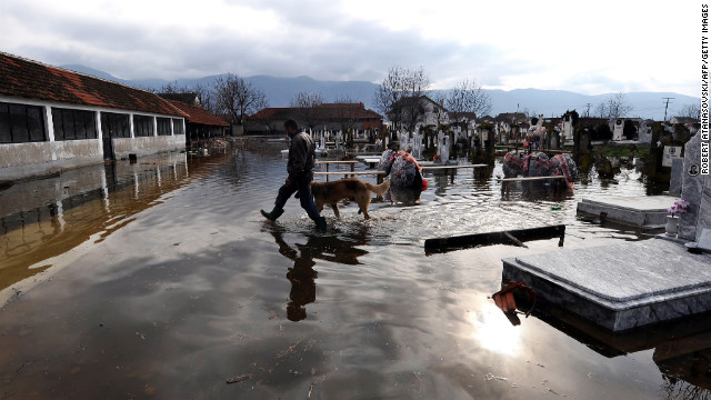 A man and a dog cross the flooded graveyard in the village of Monospitovo, Macedonia, on February 27. Torrential rains poured down on the Strumica Valley, destroying or damaging crops and households.