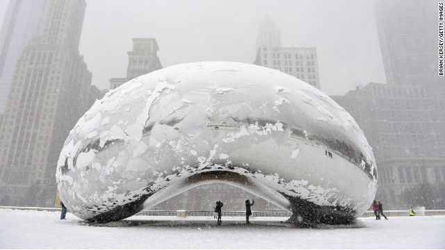 People stand under the snow-covered "Cloud Gate" sculpture, commonly known as "the bean," on Tuesday, March 5, in Chicago, Illinois. Click through the gallery to see more weather images from around the world.