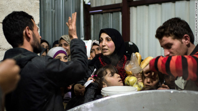 A refugee collects apples and some bread February 10 at the Azaz refugee camp along the Syrian-Turkish border. Turkey has spent more than $600 million setting up 17 refugee camps, with more under construction.