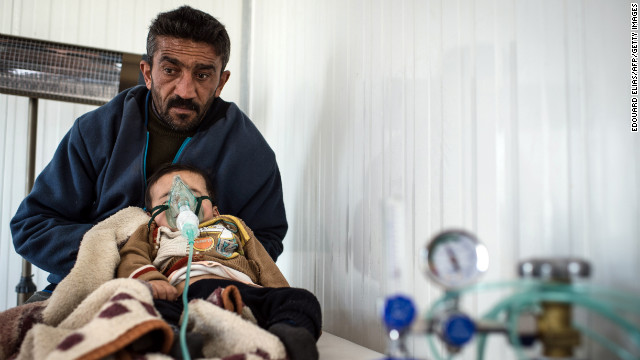 A refugee visits a clinic with his child at the Azaz refugee camp on February 10.