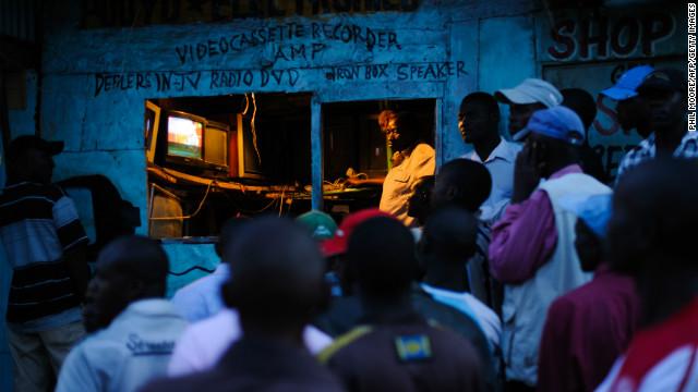 Men watch the incoming provisional election results on a television outside a shop in the Kibera slum of Nairobi, Kenya's capital, March 5, 2013.