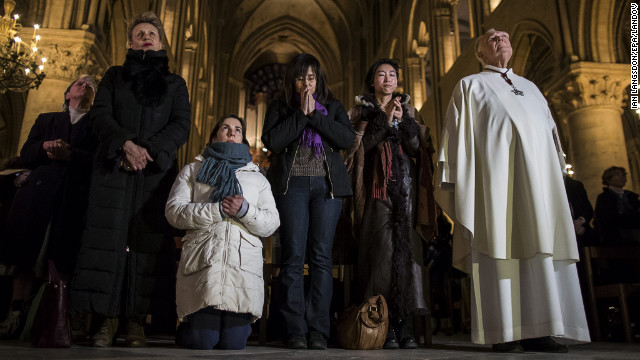 The faithful listen as Cardinal Jorge Mario Bergoglio of Argentina is announced as the new pope at Notre Dame Cathedral in Paris.