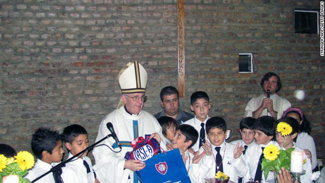 Bergoglio poses with school children and the emblem of Argentina's San Lorenzo football team. 