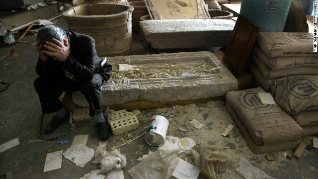 Iraqi National Museum Deputy Director Mushin Hasan sits among destroyed artifacts on April 13, 2003, in Bagdhad. The museum was severely looted.