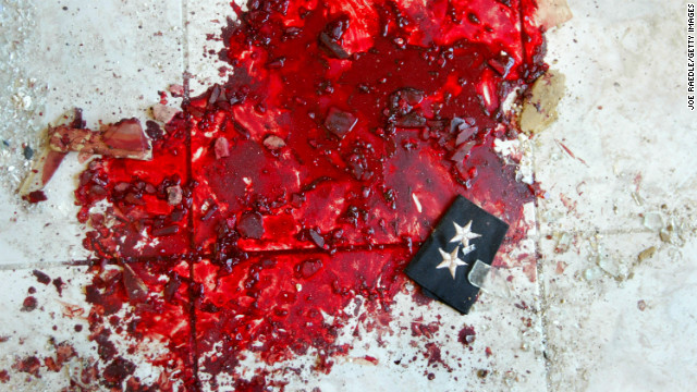An Iraqi police lieutenant's stars lie in a puddle of blood after a car bombing that targeted a police station in Baquba on November 22, 2003.