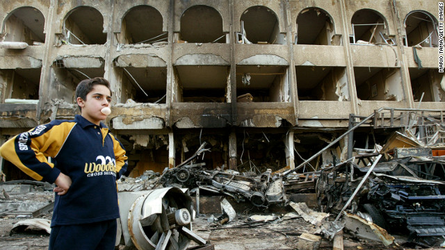 A boy stands at the scene of a car bombing in front of the Shaheen Hotel in Baghdad on January 28, 2004.