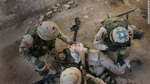 Army Sgt. 1st Class Troy Hawkins is tended to after getting wounded during a firefight while on patrol with an Iraqi army unit in the Haifa Street neighborhood of Baghdad on February 16, 2005. Afterward, he continued to fight in the narrow streets.