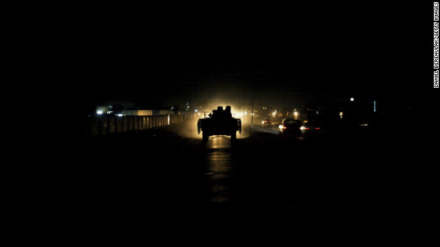 A British armored vehicle is illuminated by traffic during a patrol of Basra on July 27, 2006.