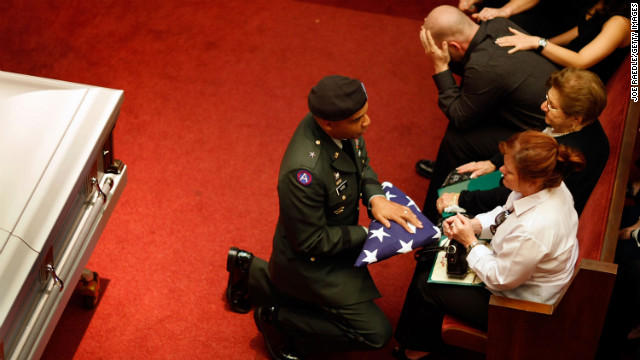 Army Brig. Gen. Nolen V. Bivens presents an American flag to Maribel Ferrero during the funeral of her 23-year-old son, Army Pfc. Marius L. Ferrero, in Miami. He was killed by a roadside bomb while serving in Iraq.
