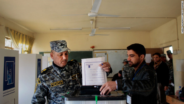 A poll worker helps a member of the Iraqi National Police cast his ballot in Baghdad on January 28, 2009. Polls were opened early to members of the Iraqi security services, many of whom would be working during the provincial elections.