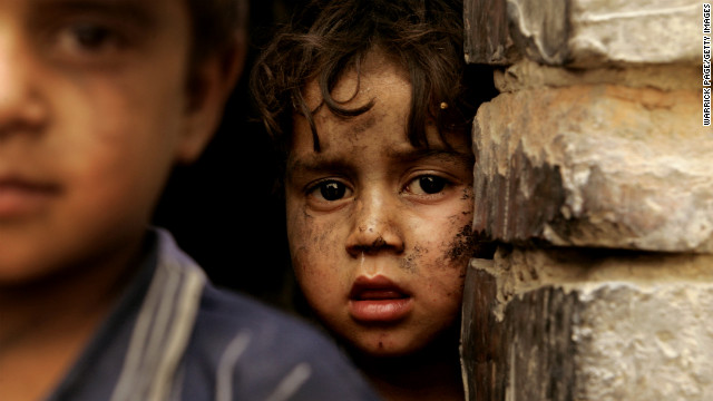 A boy looks out from his family shelter at a Narwan brick factory on July 1, 2008.