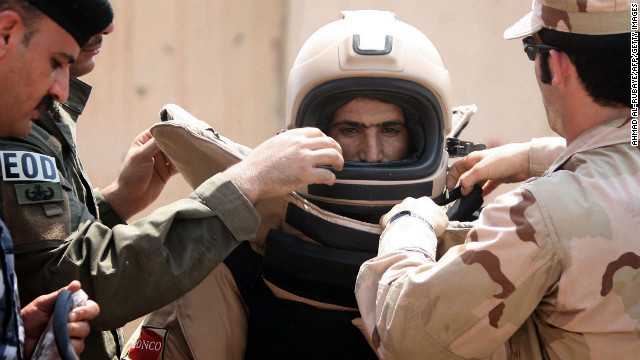 An Iraqi explosives expert gets into a special suit for bomb disposal during a training session organized by his U.S. counterparts at the Warhorse military base near the restive city of Baquba on August 17, 2010.
