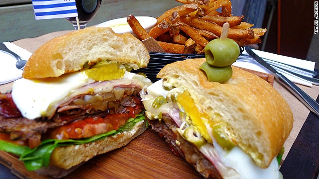 The Uruguayan chivito piles skirt steak or filet mignon with layers of ham and bacon, accompanied by onion, mayonnaise, lettuce, tomato, mozzarella, olives, hard-boiled egg and lettuce. Pictured: chivito from Tabaré in Brooklyn.