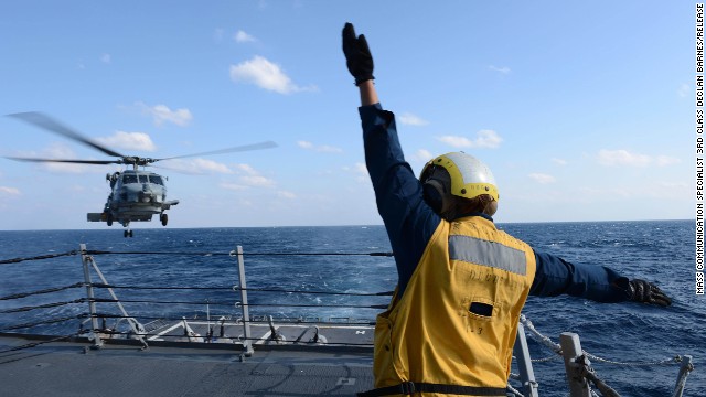 U.S. Navy Boatswain's Mate 3rd Class Brittany Chiles signals to an SH-60B Seahawk helicopter as it lands on the flight deck of destroyer USS McCampbell on March 4 in the Pacific Ocean, in this Navy handout photo.