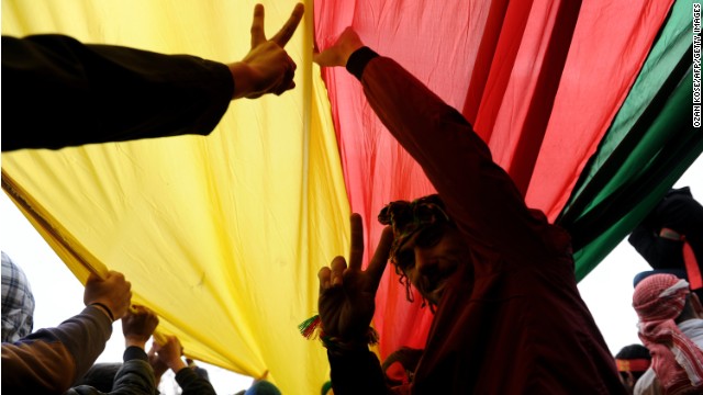 Kurds hold a giant flag of PKK (Kurdish Workers Party) and flash V-signs during celebrations on March 17, 2013 of Nowruz, the Persian New Year festival, in Kazlicesme, Istanbul.