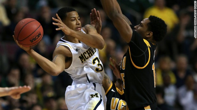 Trey Burke of the Michigan Wolverines, left, looks to pass against Juvonte Reddic of the Virginia Commonwealth Rams on March 23 in Auburn Hills, Michigan. The Wolverines won 78-53.