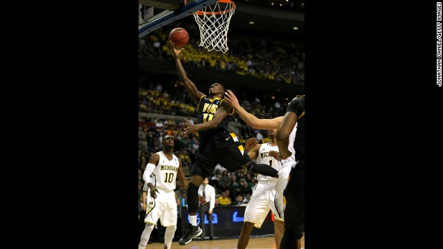 Rob Brandenberg of the Virginia Commonwealth Rams, center, drives for a shot against the Michigan Wolverines on March 23.