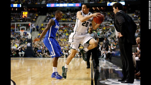 Travis Trice of Michigan State attempts to save the ball from going out of bounds while Joe Jackson of Memphis gives pursuit on March 23. Memphis coach Josh Pastner watches.