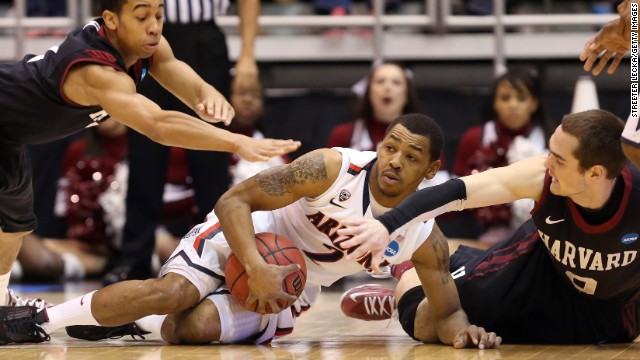 Arizona's Mark Lyons goes after a loose ball against Siyani Chambers, left, and Laurent Rivard, right, of Harvard on March 23.