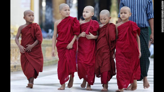 Young Buddhist monks walk on their daily alms collection at the sacred golden Shwedagon Pagoda in Yangon.