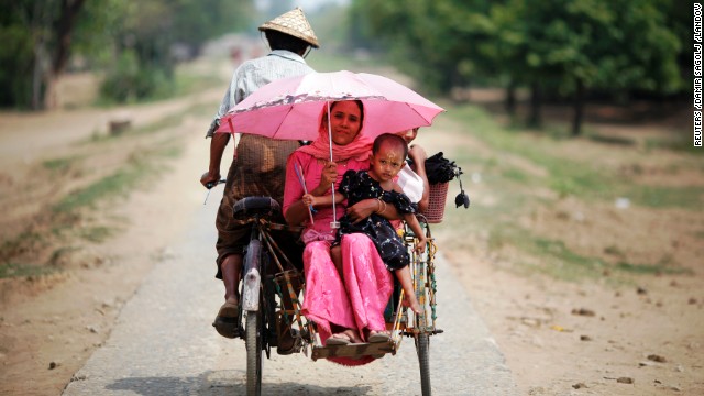 People ride in a rickshaw on a road north of the town of Sittwe.