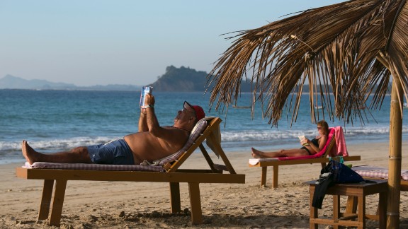 NGAPALI BEACH, MYANMAR - NOVEMBER 28: Tourists sun themselves along the quiet beach November 28, 2012 on Ngapali beach, Myanmar. Myanmar possesses great tourist potential and the country's tourism industry is developing fast. Ngapali beach, along the Andaman Sea, is considered the top beach resort with much of the surrounding area still remaining to be developed. Investment opportunities are growing every day as real estate prices increase with investor demand. (Photo by Paula Bronstein/Getty Images)