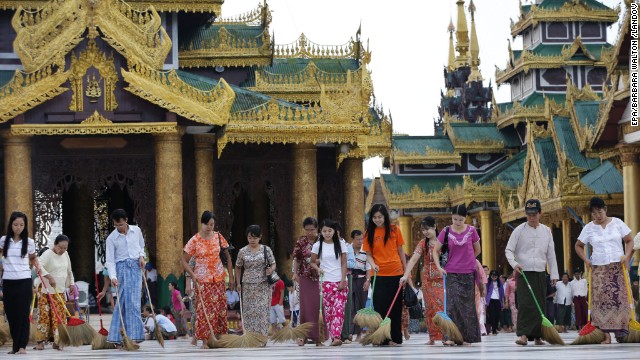 Volunteers sweep the floors at the golden Shwedagon Pagoda in Yangon.