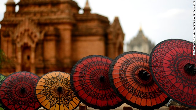 A line of umbrellas sits in front of an old building in Bagan.