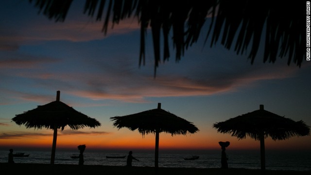 Women carry fruit baskets on their heads on Ngapali Beach.