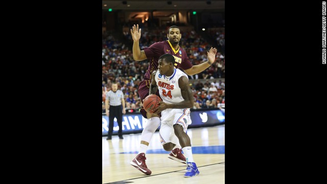 Casey Prather of Florida drives past Maurice Walker of Minnesota on March 24.