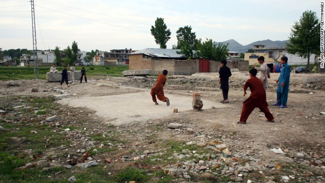 Children play cricket near the site of the demolished compound.