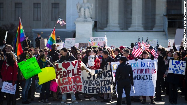 Supporters of same-sex marriage wave flags and signs as they rally in front of the U.S. Supreme Court on Wednesday, March 27, in Washington. The justices heard two cases this week related to state and federal laws restricting same-sex marriage.