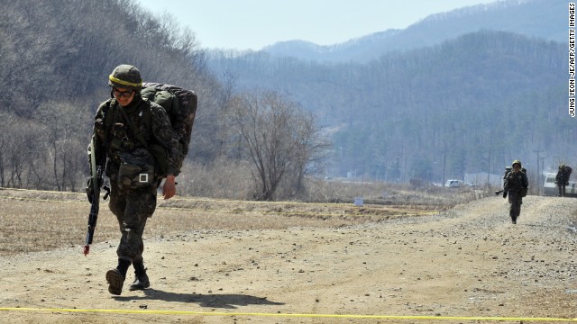 Armed South Korean soldiers walk on a road near a military drill field in Paju on March 27.