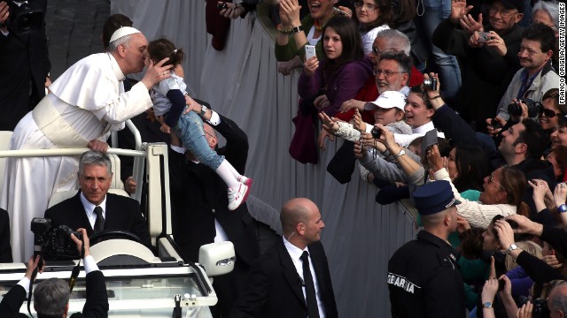 Pope Francis greets a child from an open-air jeep on Wednesday.