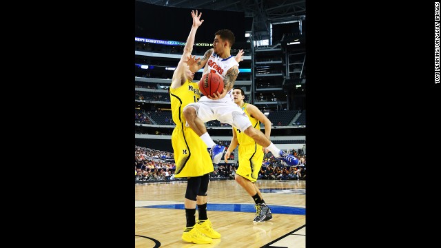 Scottie Wilbekin of Florida goes up against Nik Stauskas, left, of Michigan.