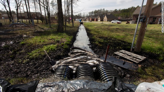 Spilled crude oil is seen in a drainage ditch near evacuated homes in Mayflower, Arkansas, on Sunday, March 31. An Exxon Mobil pipeline carrying Canadian crude oil ruptured on Friday causing the evacuation of about two dozen homes.