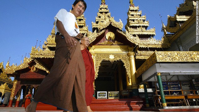 The traditional Burmese dress is the longyi, a wraparound skirt worn by men and women. Men tie theirs in the front and women fold the cloth over and secure it at the side. Here, a longyi-clad visitor walks inside the Shwedagon Pagoda in Yangon. 