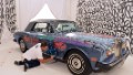 US graffiti artist Jonone performs a painting on a Rolls Royce car owned by former French football player turned actor Eric Cantona during the TV show 'Le grand journal' on a set of French TV Canal+, on November 22, 2012 in Paris during the launching of French charity association Abbe Pierre Foundation's winter campaign. 