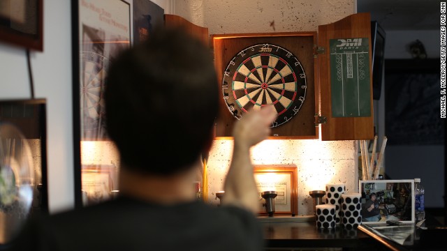 Staffers and interns play darts during some downtime on the weekend shift at CD102.5. 