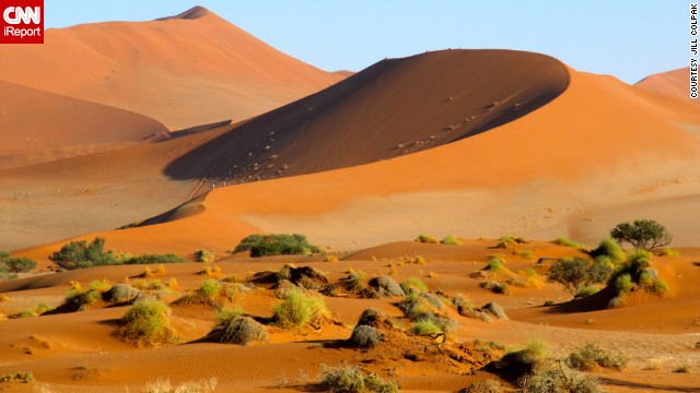 The morning sun casts a glow over the <a href='http://ireport.cnn.com/docs/DOC-931537'>sand dunes</a> of Namibia.