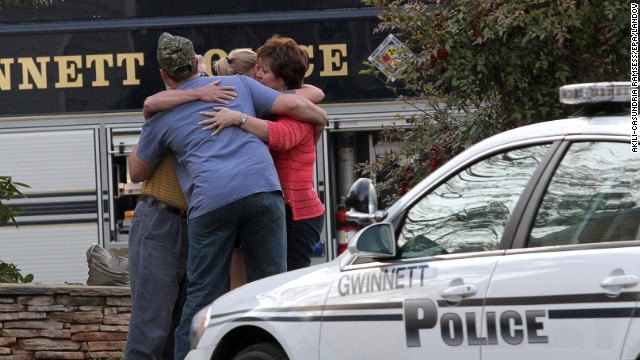Neighbors embrace after a hostage situation ends in Suwanee, Georgia, on Wednesday, April 10. A gunman in apparent financial distress took several firefighters hostage the Atlanta suburb, then was killed in an exchange of gunfire hours later after law enforcement authorities determined he might lash out at his captives.