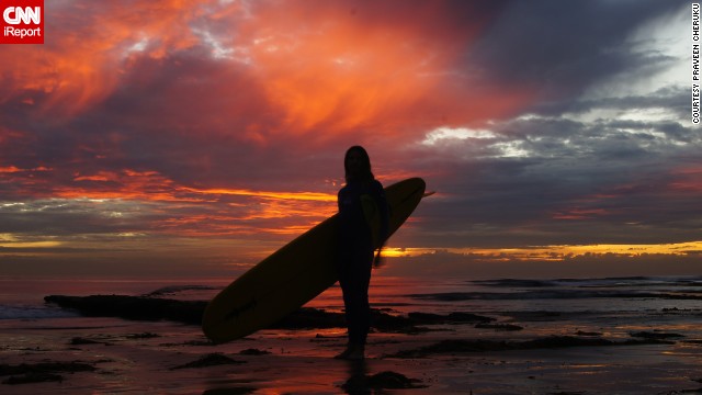 A surfer enjoys the sun on <a href='http://ireport.cnn.com/docs/DOC-883727'>Swami's Beach</a> before swimming out to sea.