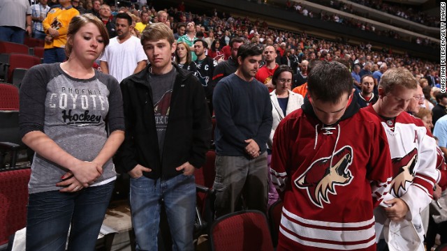 Fans pause for a moment of silence before the NHL game between the Phoenix Coyotes and the San Jose Sharks on Monday in Glendale, Arizona. See the world reaction to the attack.