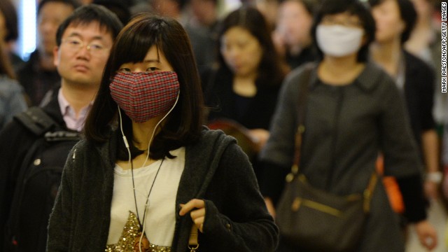 Pedestrians in Shanghai wear face masks to protect themselves from the H7N9 bird flu virus on Tuesday, April 16. 