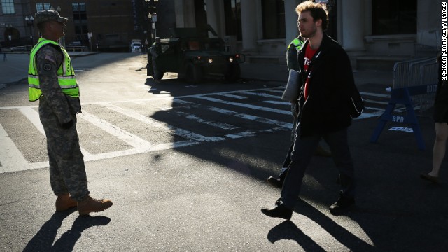 Pedestrians pass National Guard troops at a roadblock on April 16. 